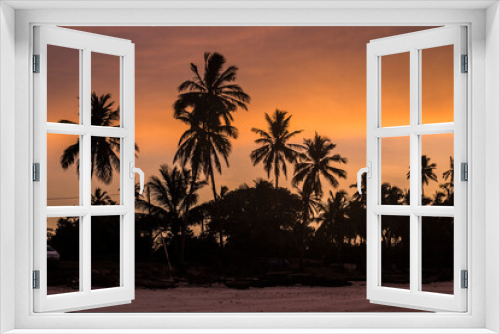 Fototapeta Naklejka Na Ścianę Okno 3D - Silhouette of palm trees against orange sunset sky. Beautiful sunrise at Zanzibar, Tanzania