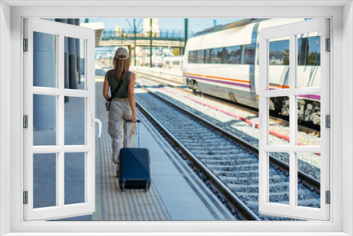 Woman traveler tourist walking with luggage at train station. Active and travel lifestyle concept. Copy space