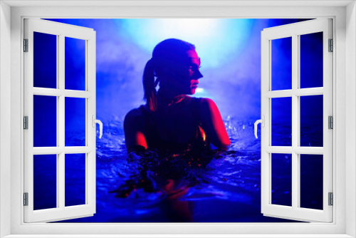 Fototapeta Naklejka Na Ścianę Okno 3D - Sensual woman in leather BDSM mask dancing in swimming pool, neon light.