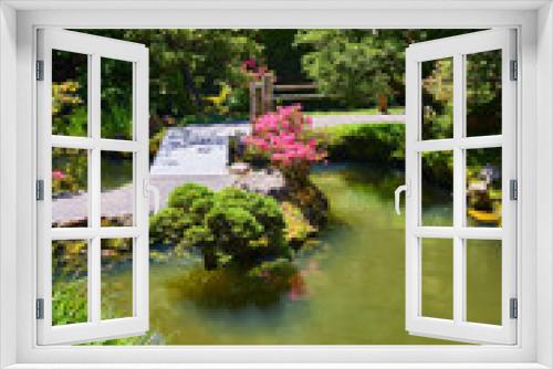 Fototapeta Naklejka Na Ścianę Okno 3D - Small pond with lily pads and flowers with path through simple garden