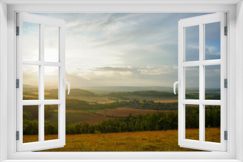 Fototapeta Naklejka Na Ścianę Okno 3D - Looking at a sunset on countryside and farm fields