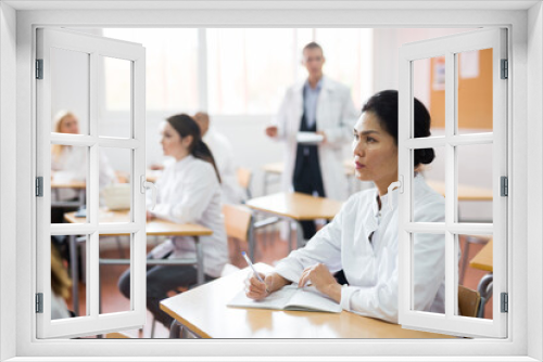 Portrait of confident asian female doctor listening lectures within refresher course. Professional development concept