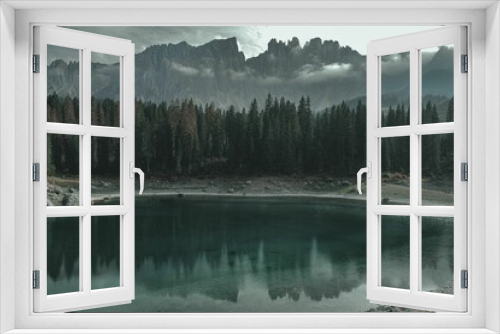 Fototapeta Naklejka Na Ścianę Okno 3D - Small alpine lake surrounded by lush pine trees and mountains.