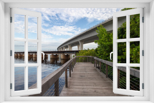 Fototapeta Naklejka Na Ścianę Okno 3D - Boardwalk along a river under a bridge in Stuart, Florida