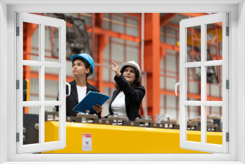 two professional woman engineer,worker,technician use clipboard discuss work, walk in steel metal manufacture factory plant industry. woman wear hard hat check quality machine