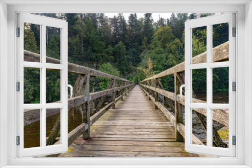 Fototapeta Naklejka Na Ścianę Okno 3D - Wooden bridge over the river in the forest on a summer day