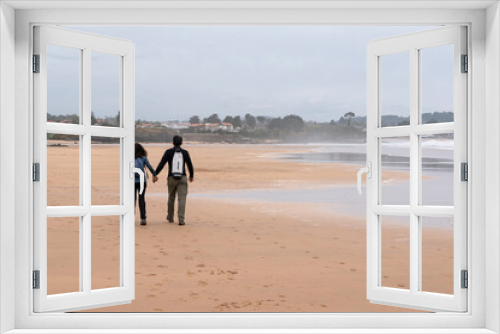Fototapeta Naklejka Na Ścianę Okno 3D - Couple walks hand in hand on the beach. Asturias