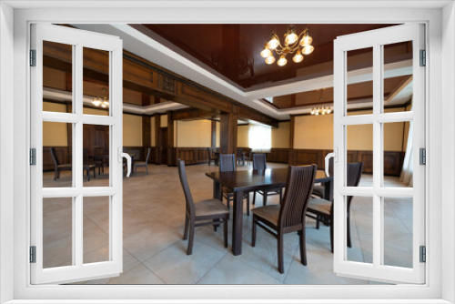 spacious interior of modern empty large restaurant with tables and chairs.