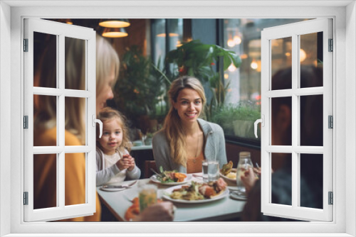 A happy smiling young woman with her little daughter and family in a restaurant and eating brunch.