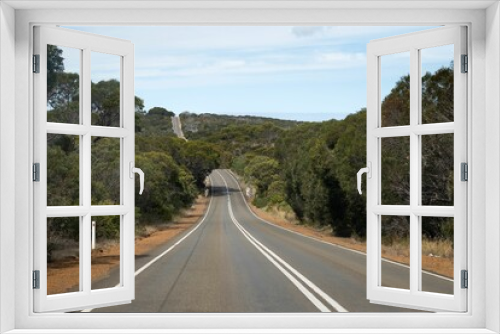 Fototapeta Naklejka Na Ścianę Okno 3D - a truck drives down an empty country road surrounded by trees