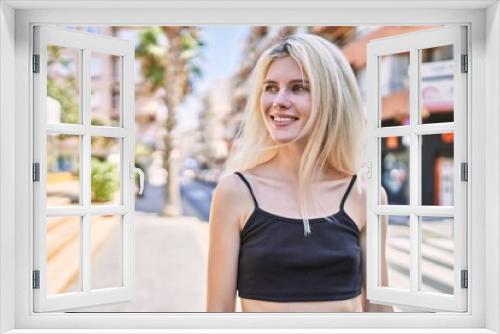 Young blonde woman smiling confident looking to the side at street