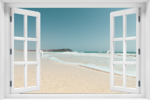 Fototapeta Naklejka Na Ścianę Okno 3D - Weiter Strand mit Ocean und Kitesurfer im Hintergrund am Horizont 