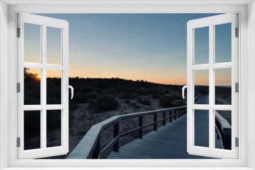 Fototapeta Naklejka Na Ścianę Okno 3D - Boardwalk to the ocean, orange horizon, blue pure sky, no people