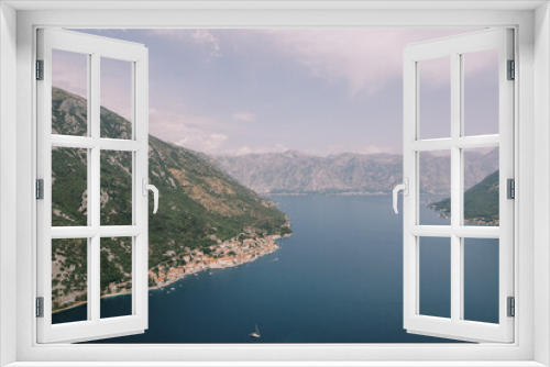 Fototapeta Naklejka Na Ścianę Okno 3D - Sailing yacht sails along the Bay of Kotor with the coast of Perast in the background. Montenegro. Aerial view