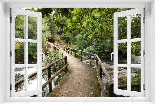 Fototapeta Naklejka Na Ścianę Okno 3D - Stone bridge over a beautiful landscape formed by small waterfalls on stones within a lush and green forest. Concept landscape, water, forest, vegetation, humidity.