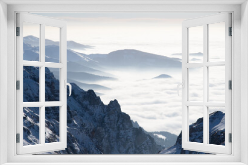 Fototapeta Naklejka Na Ścianę Okno 3D - A majestic range of snow-capped peaks concealed amongst billowing clouds
