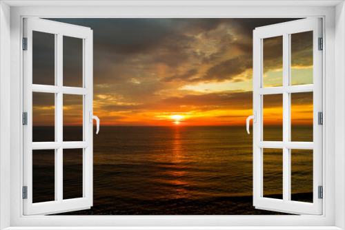 Fototapeta Naklejka Na Ścianę Okno 3D - During early morning hours, sun rises over waves ocean