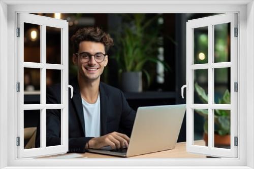 A happy business man sit on a table with laptop