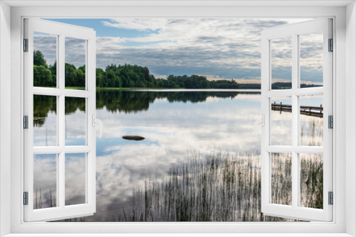 Fototapeta Naklejka Na Ścianę Okno 3D - Lake landscape. A view of the lake in summer with the reflection of the forest and clouds in the water