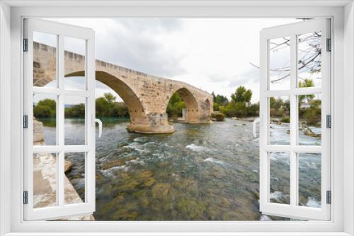 Fototapeta Naklejka Na Ścianę Okno 3D - Seljuk bridge in Aspendos. The Eurymedon Bridge. Aspendos Yolu Belkis Mevkii. Turkey. Crooked bridge. Bridge over the Kopruchay (Euremedon) River near Aspendos, in Pamphylia, in southern Anatolia