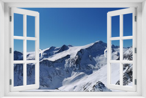 Fototapeta Naklejka Na Ścianę Okno 3D - Aerial view of snowy rocky mountains on blue sky background