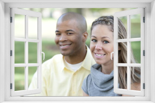 Happy young interracial couple posing together on a sunny day.