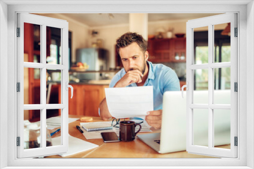 Young man looking at paper document with concern at home