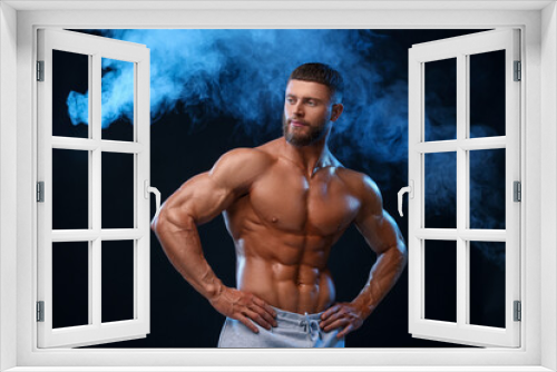 Fototapeta Naklejka Na Ścianę Okno 3D - Young bodybuilder with muscular body in smoke on color background