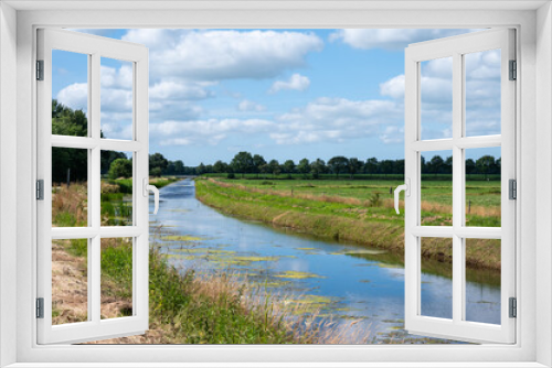 Fototapeta Naklejka Na Ścianę Okno 3D - Creek through green wetlands over blue sky at the Oostervoorts Diep national park