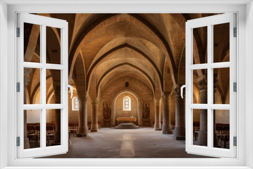 The interior of a Romanesque church, featuring barrel vaults, rounded arches, and timeless religious art.