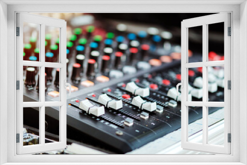 Sound mixer with orange flare at the audio control studio.