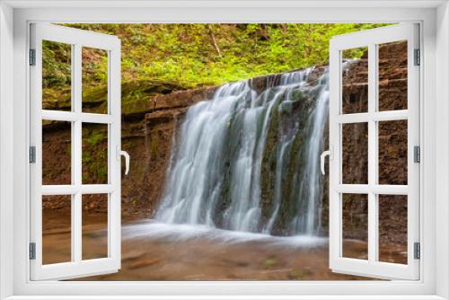 Fototapeta Naklejka Na Ścianę Okno 3D - Scenic waterfall in a mountain stream in the forest. One of the waterfalls of the cascade of Rusiliv waterfalls. Rusyliv, Ternopil Region, Ukraine