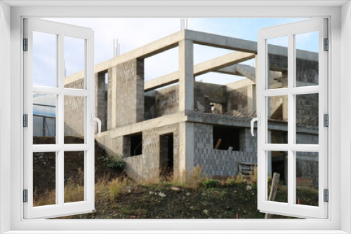 Fototapeta Naklejka Na Ścianę Okno 3D - box of a two-story cottage under construction without a roof, a block building at the stage of erecting walls, construction of a residential building in a suburban area