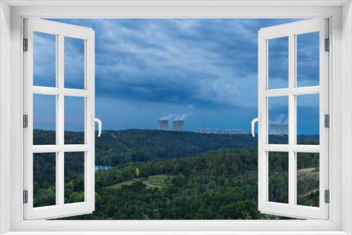 Fototapeta Naklejka Na Ścianę Okno 3D - Dukovany nuclear power plant in the Czech Republic, Europe. Smoke cooling towers. There are clouds in the sky. In the foreground is the nature of the Highlands.