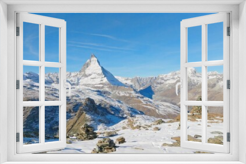 Fototapeta Naklejka Na Ścianę Okno 3D - Majestic mountain peaks full of stacked rock hiker cairns with famous Matterhorn view background during winter in Switzerland. Swiss alps wonderful inspiring nature landscape.