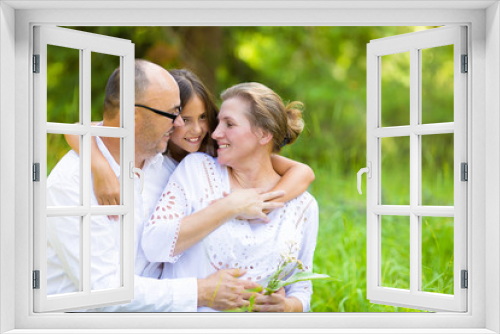 Happy family, grandparents, granddaughter outdoors on sunny day