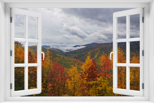 Storm clouds over the mountains covered in Fall color