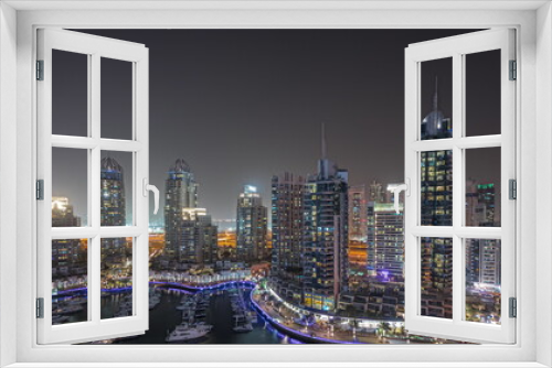 Fototapeta Naklejka Na Ścianę Okno 3D - Panorama showing Dubai marina tallest skyscrapers and yachts in harbor aerial night timelapse.