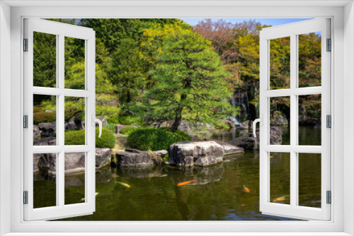 Fototapeta Naklejka Na Ścianę Okno 3D -  Idyllic Japanese Garden Scene; Koi Fish Swimming Amongst Boulders and Cascading Waterfall