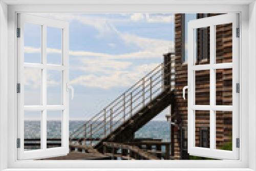Fototapeta Naklejka Na Ścianę Okno 3D - 海辺にある茶色の木造の建物、海に続く階段
