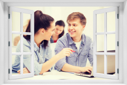 two smiling students with laptop computer