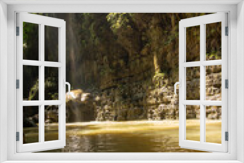 Fototapeta Naklejka Na Ścianę Okno 3D - A serene waterfall cascading into a tropical forest river.