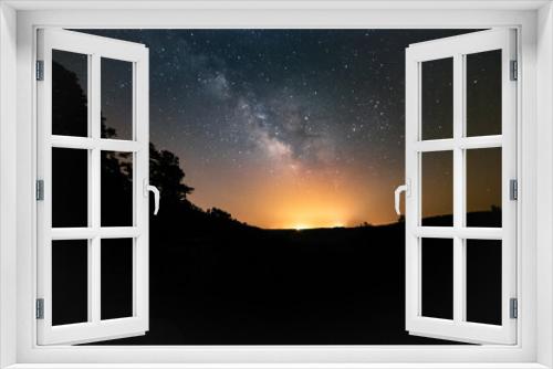 Fototapeta Naklejka Na Ścianę Okno 3D - The starry sky and Milky Way above open fields and trees