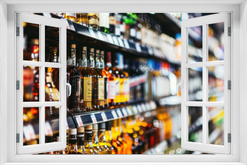 Rows of alcohol bottles on shelf in supermarket