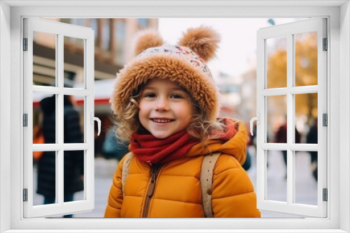 Portrait of cute little girl in hat and scarf on the street