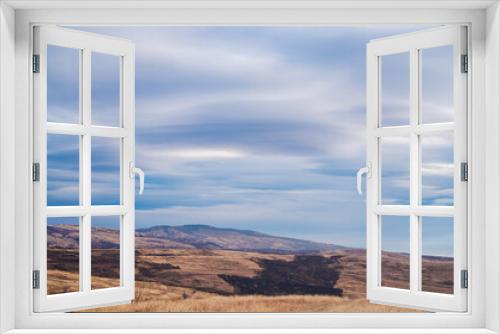 Fototapeta Naklejka Na Ścianę Okno 3D - landscape in a hilly area with white clouds.