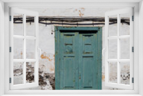 Fototapeta Naklejka Na Ścianę Okno 3D - Peeled off wall of a house with green door