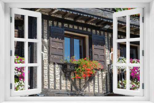 Fototapeta Naklejka Na Ścianę Okno 3D - Detalle panorámico de casa con balcones hermosamente adornados con macetas y tiestos con flores en la villa de La Alberca, España