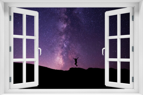 Fototapeta Naklejka Na Ścianę Okno 3D - Silhouette of a hiker jumping  on the hill, on the milky way galaxy background.