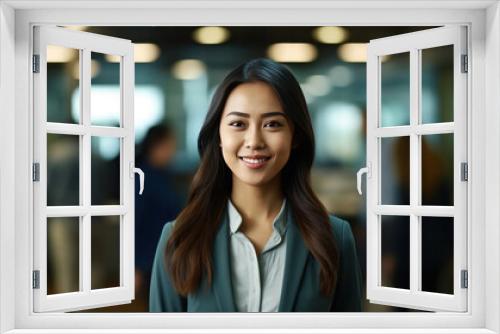 Asian business woman standing in an office smiling confidently. Business corporate people background.